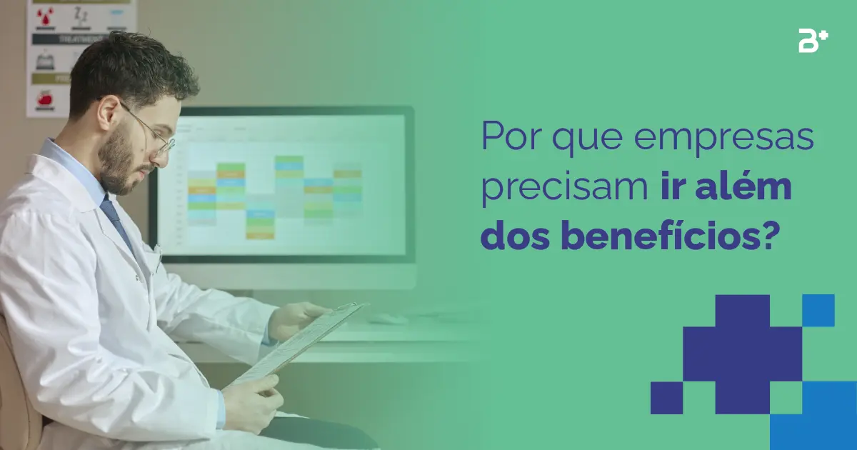 Por que empresas precisam ir além dos benefícios? Imagem do médico olhando para uma ficha nas mãos com um computador ao lado.